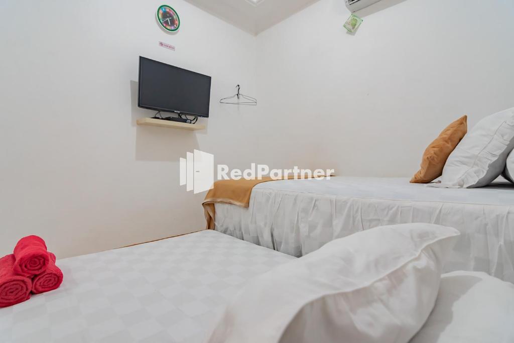 Postel nebo postele na pokoji v ubytování Langkar Guest House Syariah Mitra RedDoorz