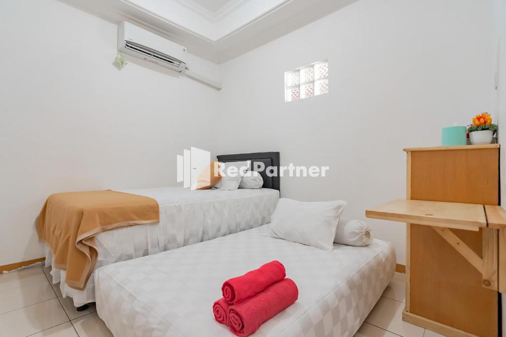 Postel nebo postele na pokoji v ubytování Langkar Guest House Syariah Mitra RedDoorz