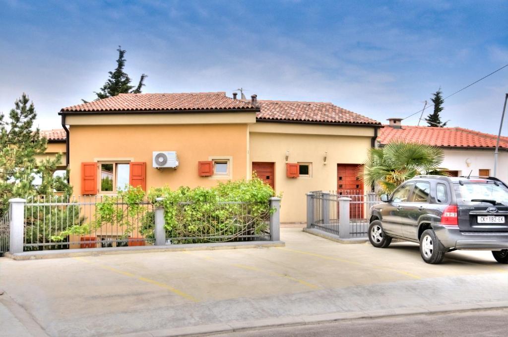 a car parked in front of a house at Apartments Casia in Baška