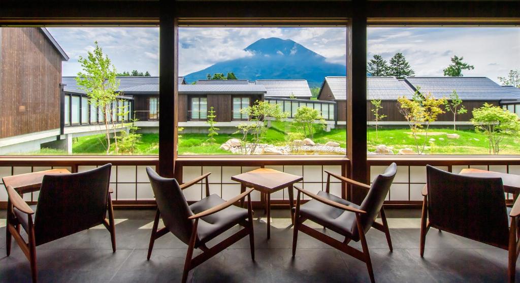 um quarto com uma mesa e cadeiras e uma grande janela em NISEKO Inn of Youtei Raku Suisan em Kutchan