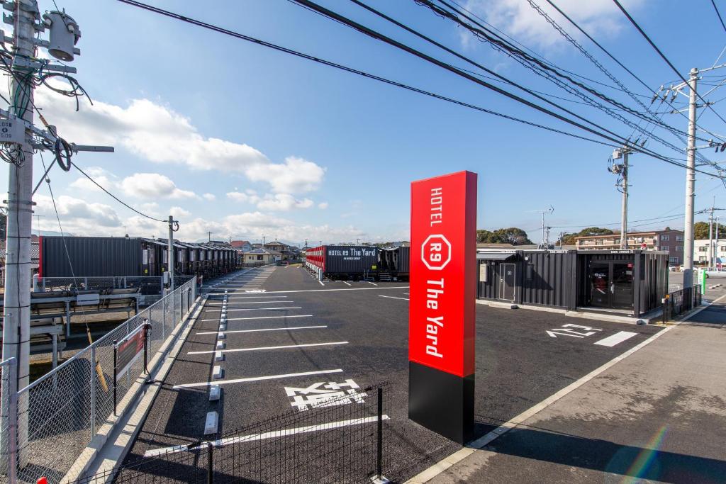 an empty parking lot with a red sign on it at HOTEL R9 The Yard Nakatsu in Nakatsu