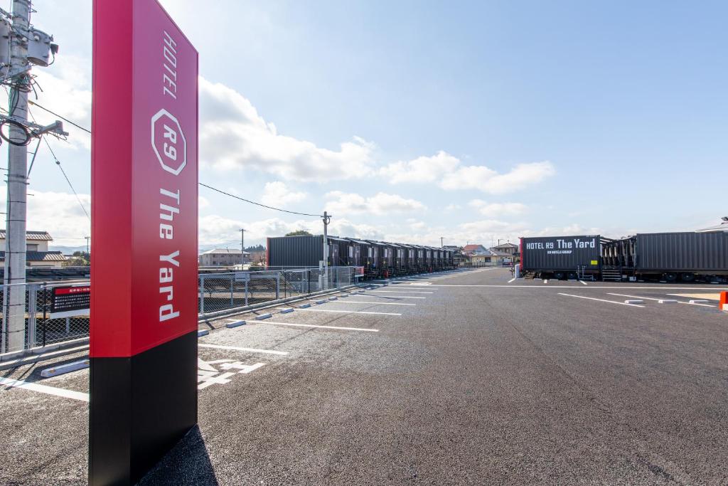 an empty parking lot with a row of train cars at HOTEL R9 The Yard Nakatsu in Nakatsu