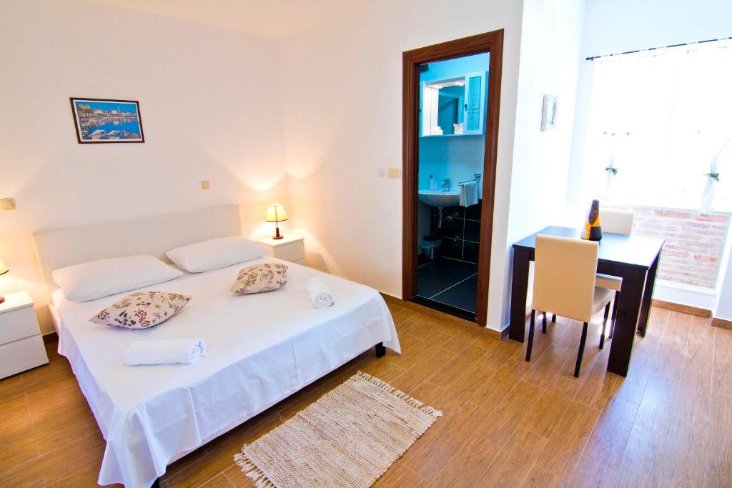 Schlafzimmer mit einem Bett, einem Tisch und einem Schreibtisch in der Unterkunft Luxury Old Town Suites in Split