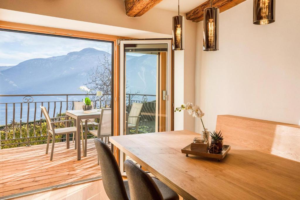 een eetkamer met een tafel en een balkon bij Brantenhof Ferienwohnung Pomum in Cortaccia