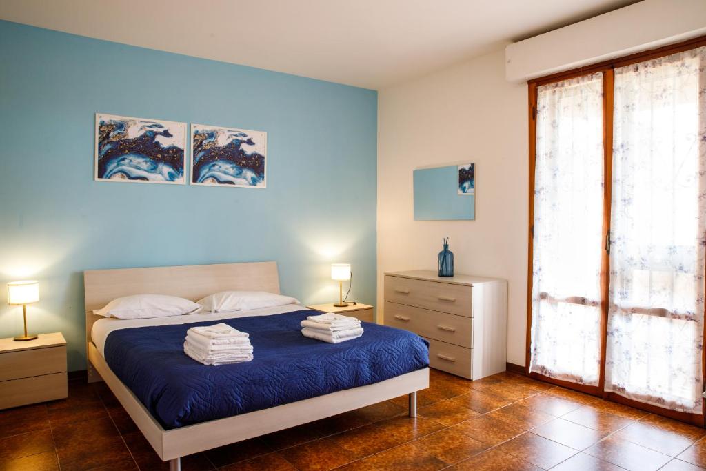 una camera blu con un letto e una finestra di Etruria Airport a Pisa