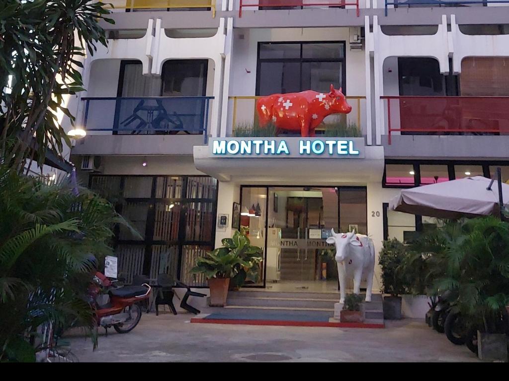 a hotel with a cow statue in front of it at Hotel Montha in Chiang Mai