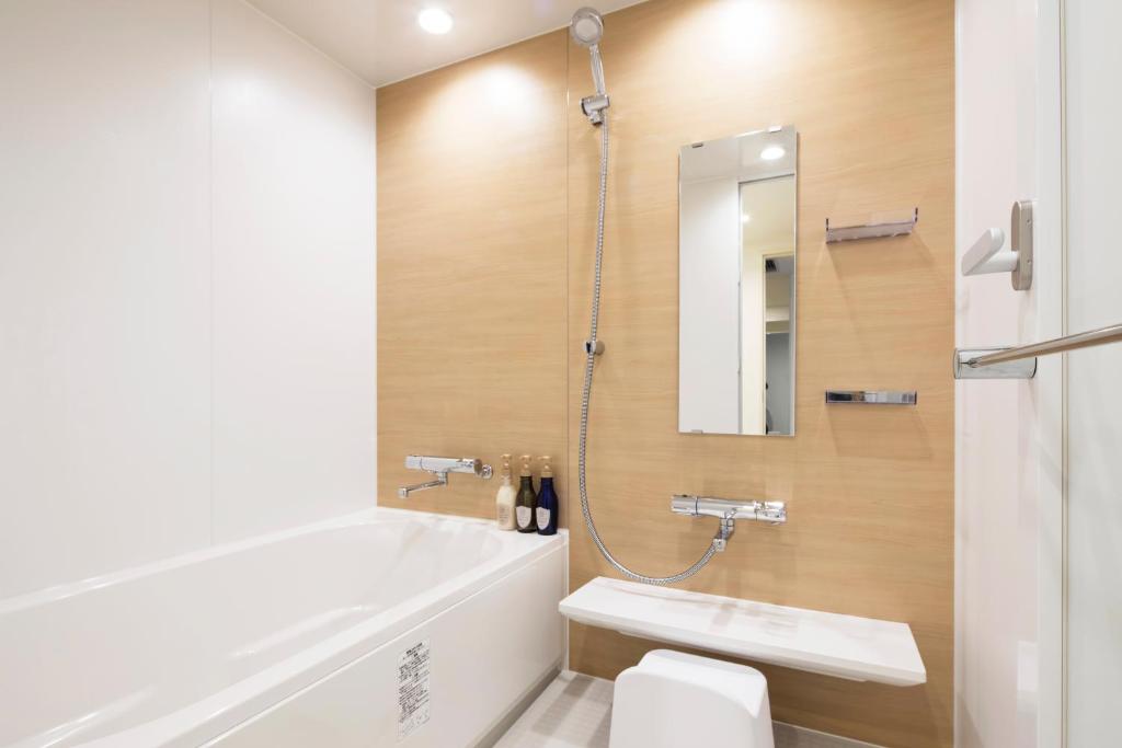 a bathroom with a toilet and a sink and a tub at HOTEL MYSTAYS PREMIER Omori in Tokyo