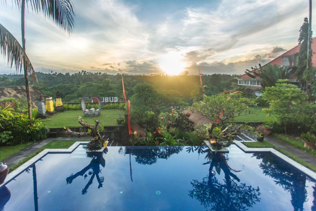 uitzicht op een zwembad in een resort bij Anhera Suite Ubud in Ubud