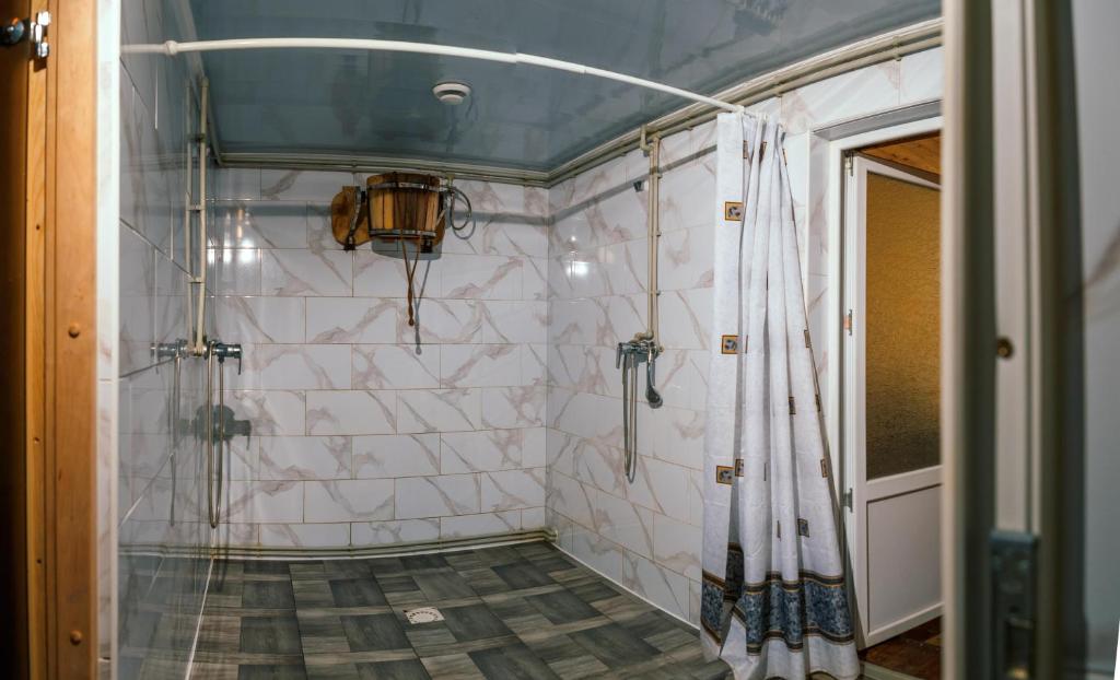 a bathroom with a shower with a tiled wall at Karpatskyi Teremok in Verkhovyna