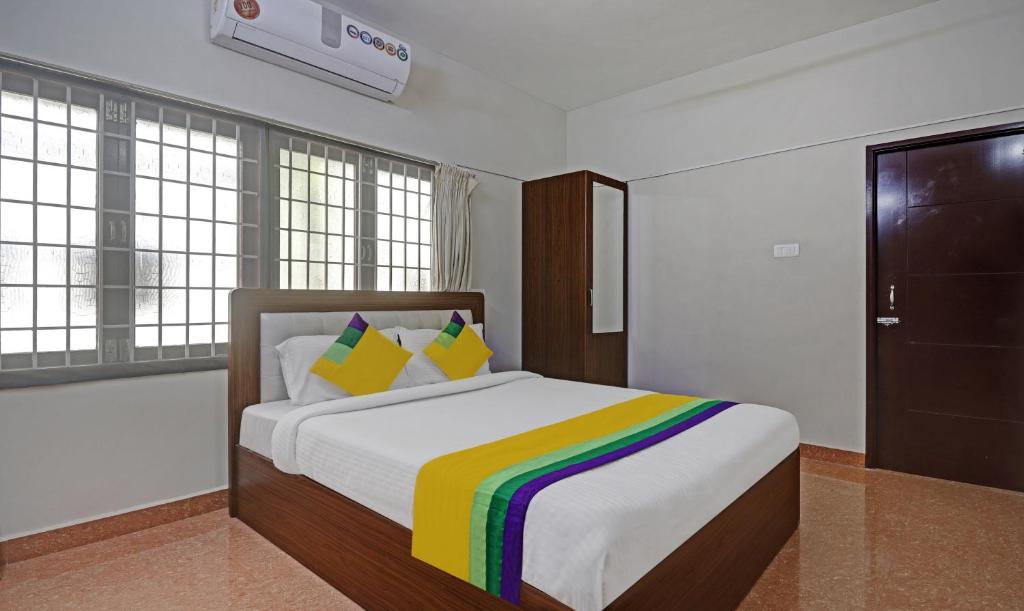 a bedroom with a bed with a rainbow blanket at Itsy Hotels Rithika Inn Blossoms in Chennai