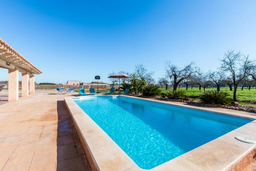 una piscina de agua azul en un patio en Villa Capo, en Búger