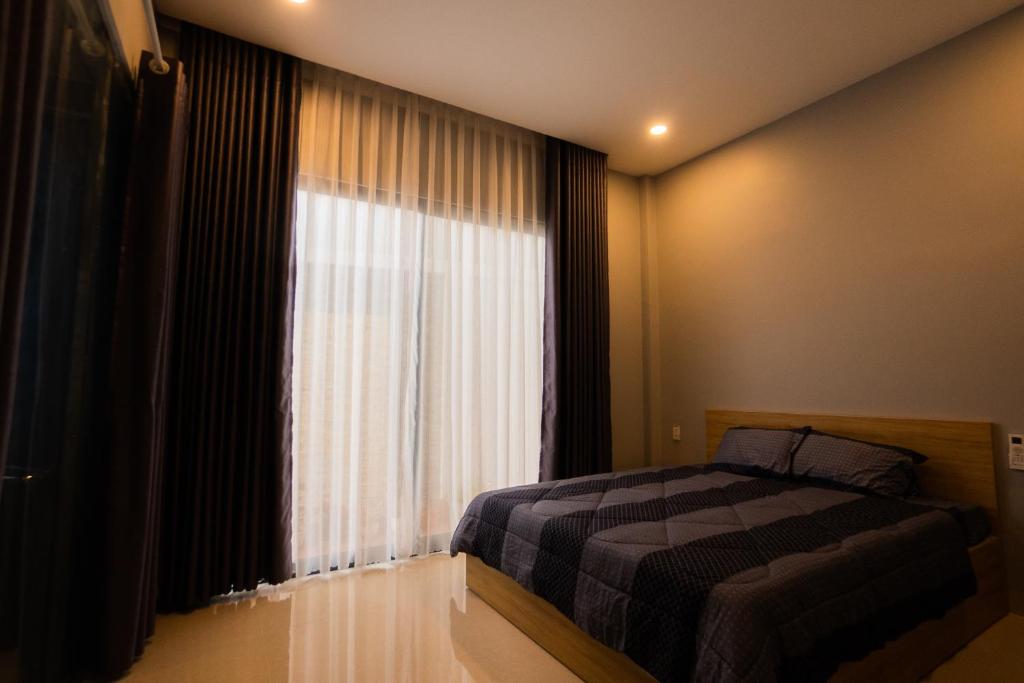 a bedroom with a bed and a large window at Nemo Homestay in Hue