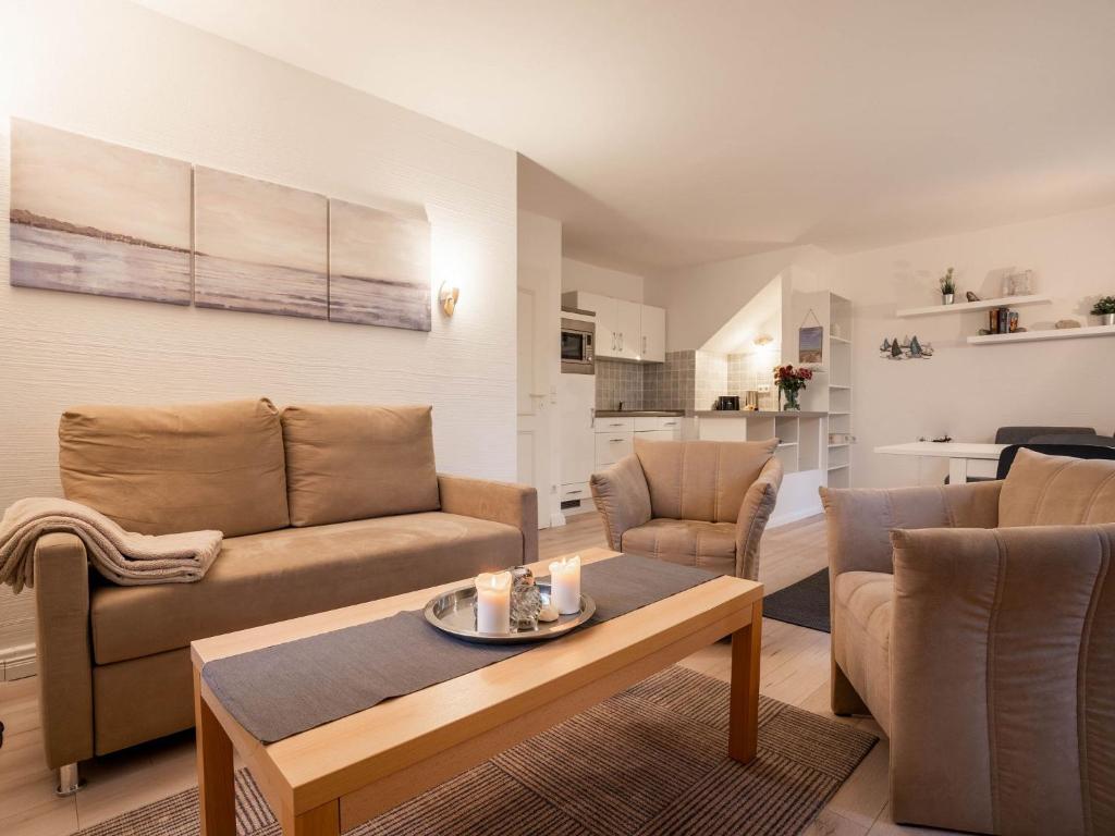sala de estar con sofá, sillas y mesa en Feriendorf Rugana - Komfort Appartement mit 1 Schlafzimmer und Terrasse B16, en Dranske