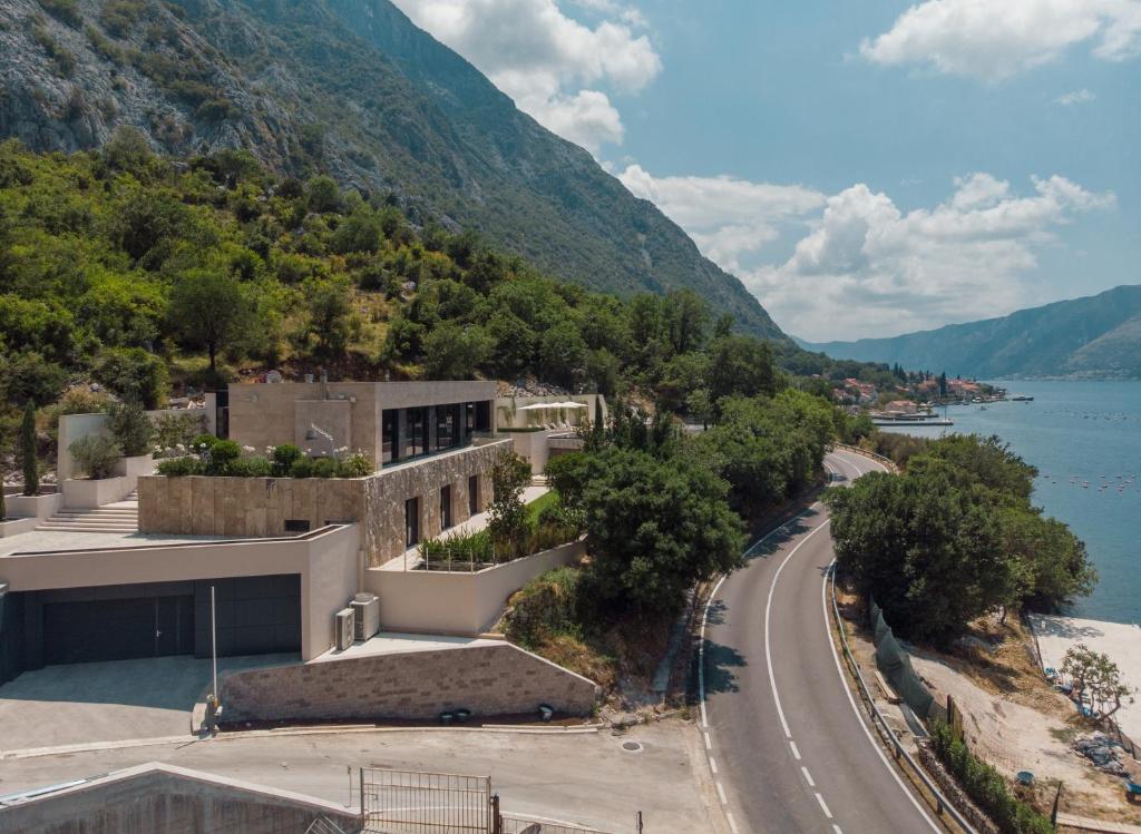 arial view of a building with a road and a mountain at Villa Mandragora in Kotor