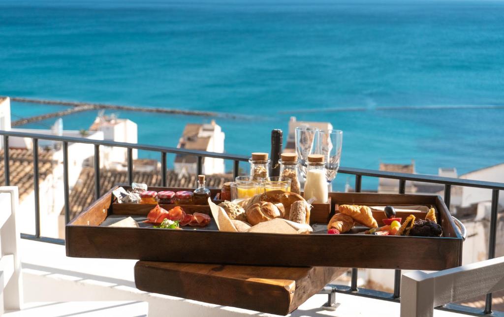 a tray of food on a table with the beach at Porta Nova Suites - Room Breakfast & Sea View in Altea