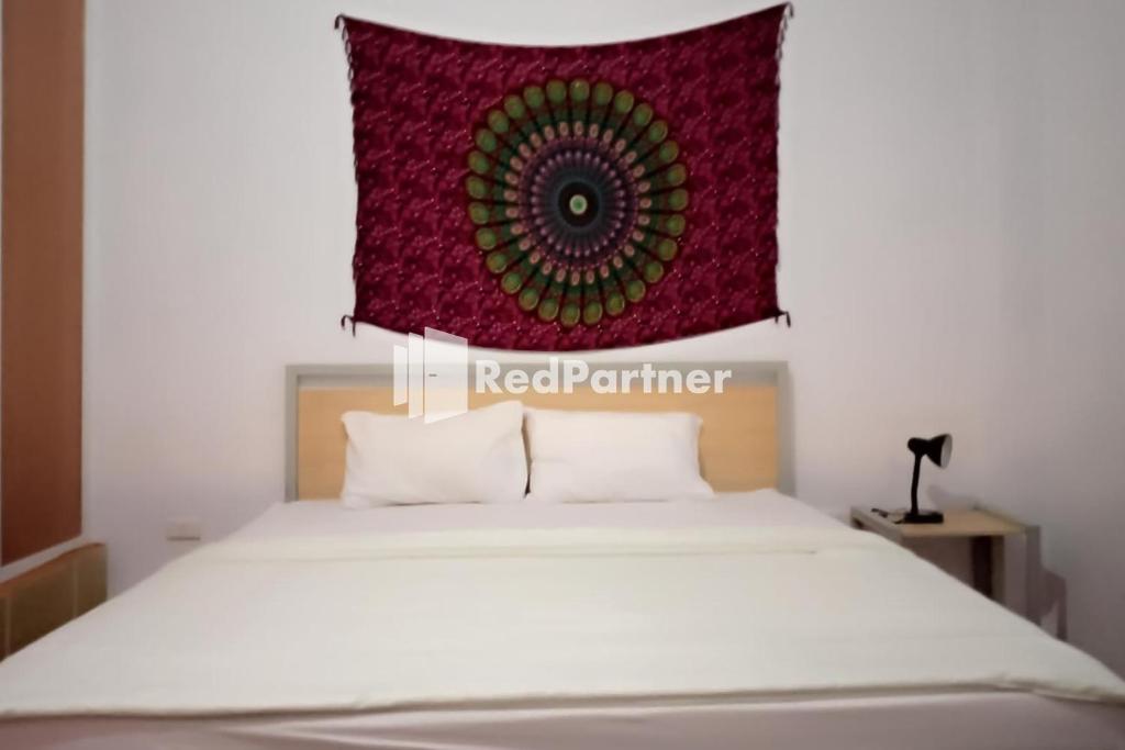 Pasifik Hotel Sabang Mitra RedDoorz في سابانغ: غرفة نوم يوجد فوقها سرير ذو نمط احمر