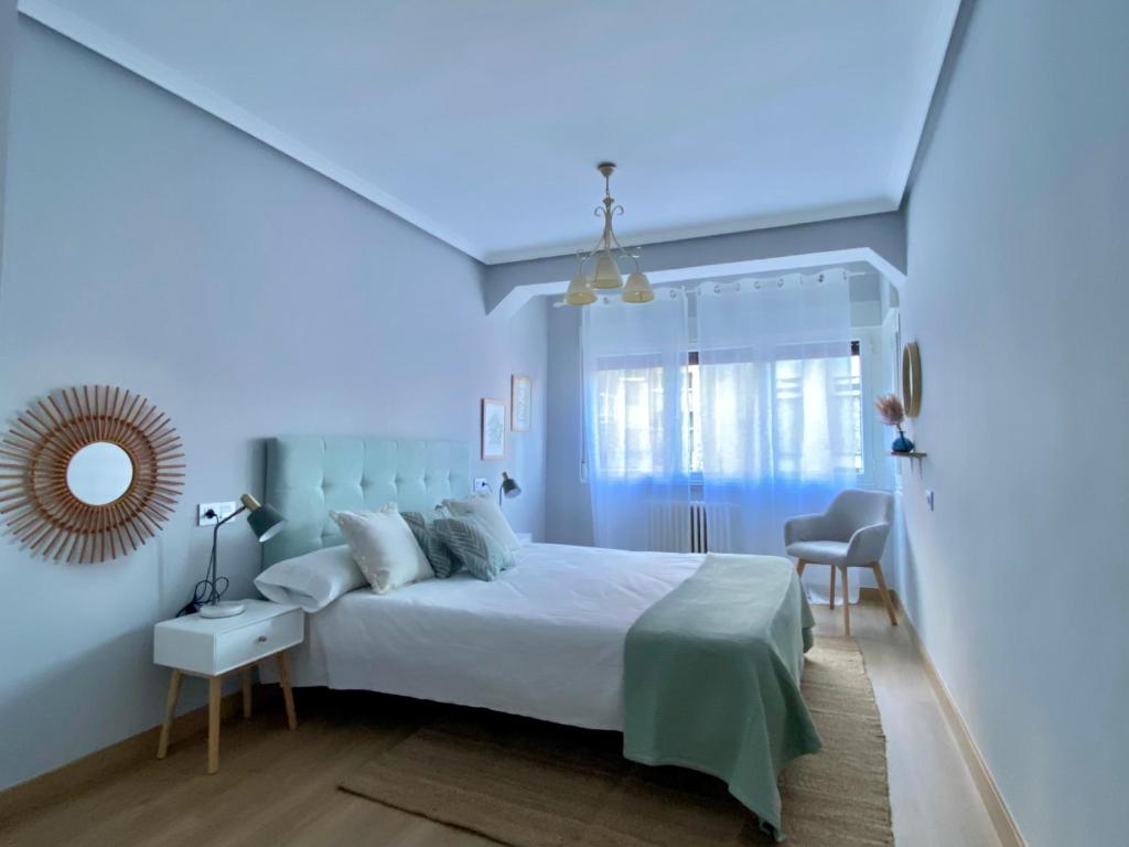 a blue bedroom with a bed and a mirror at Housingleón San Isidoro in León
