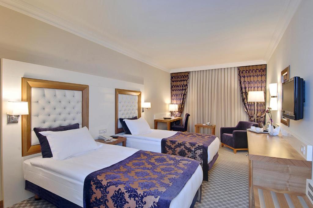 A bed or beds in a room at Tugcu Hotel Select