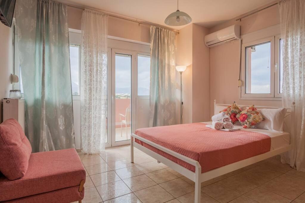 a bedroom with a bed and a window and a couch at Faidra 03 at TEI in Heraklio