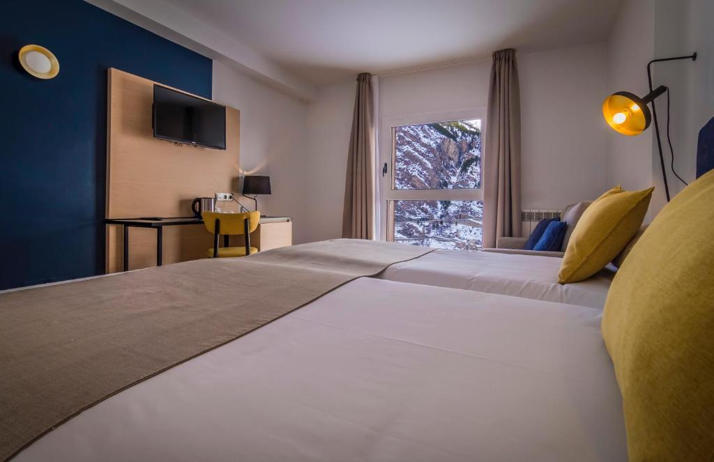 カニーリョにあるHotel Roc Melerの窓のある大きな白いベッドのある寝室