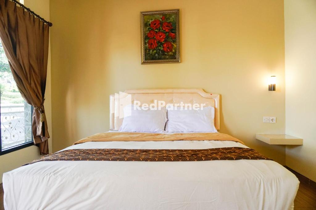 Postel nebo postele na pokoji v ubytování Griya Imafa Inn RedPartner near Jatim Park 2