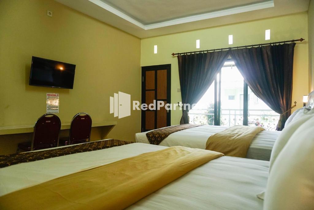 Postel nebo postele na pokoji v ubytování Griya Imafa Inn RedPartner near Jatim Park 2