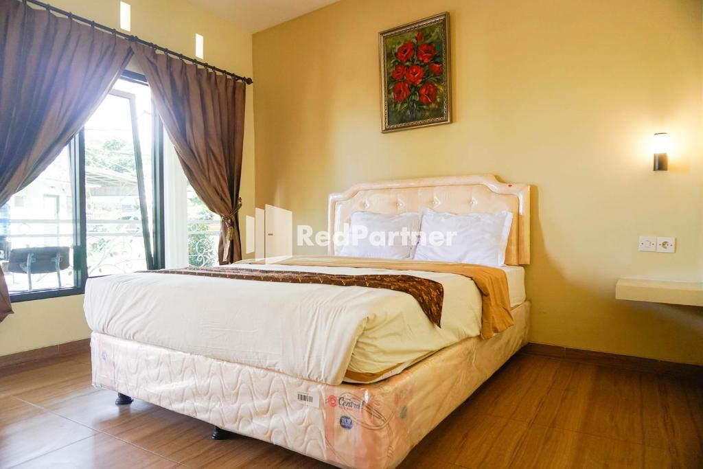 Postel nebo postele na pokoji v ubytování Griya Imafa Inn RedPartner near Jatim Park 2