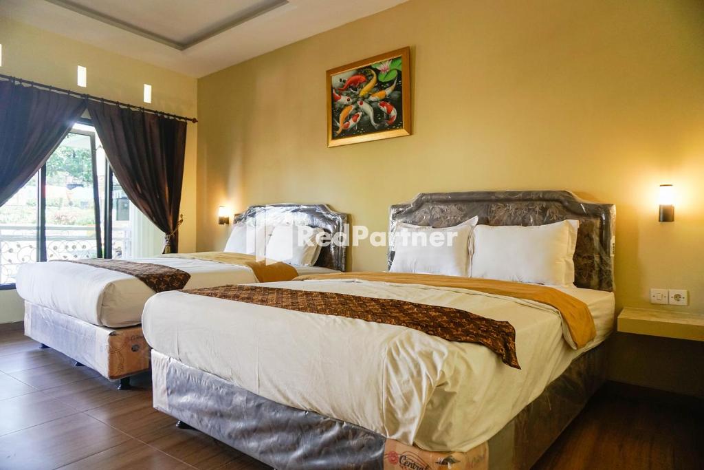 Postel nebo postele na pokoji v ubytování Griya Imafa Inn RedPartner near Jatim Park 2
