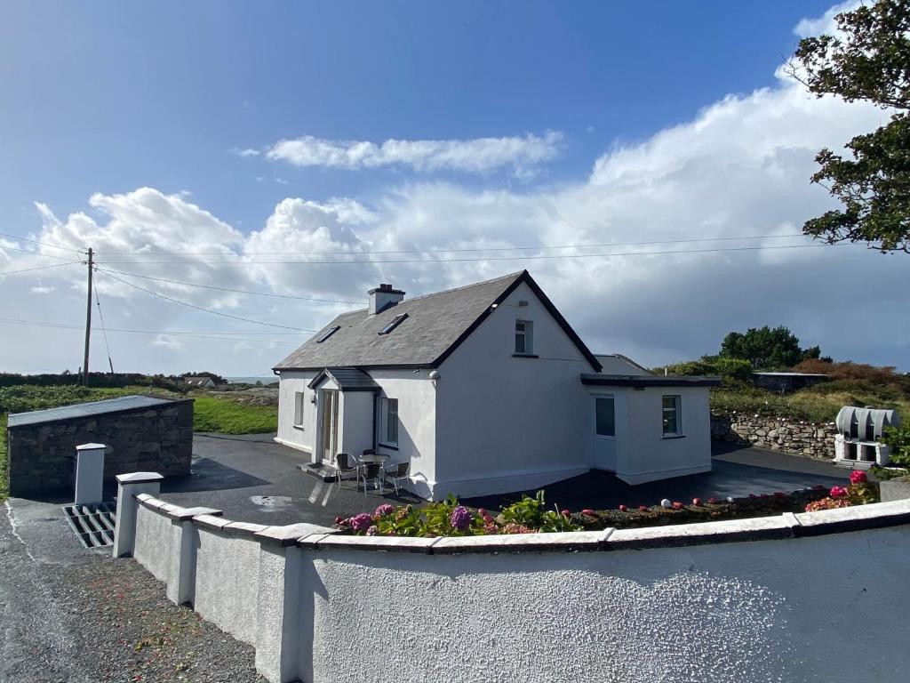 a white house on the side of a road at Cottage 397 - Carna in Carna