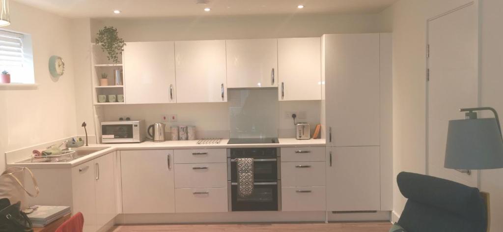 een keuken met witte kasten en een magnetron bij Apartment one Estuary Reach in Exmouth