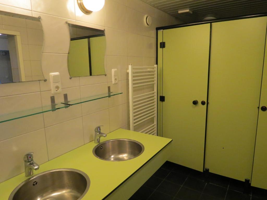 La salle de bains est pourvue de 2 lavabos et d'un comptoir vert. dans l'établissement Safaritent de Berghoeve, à Ruinen