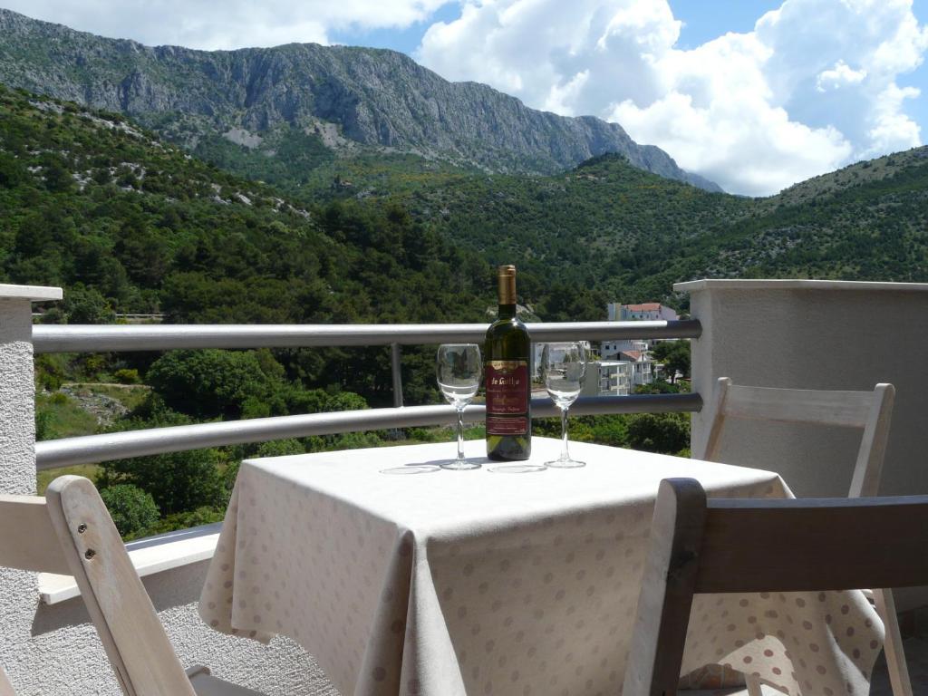 a bottle of wine sitting on a table with wine glasses at Studio Andric in Drvenik