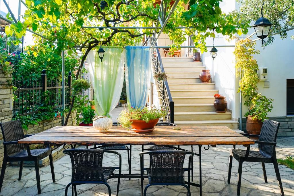 a wooden table and chairs on a patio at il giardino in Skala Kallirakhis