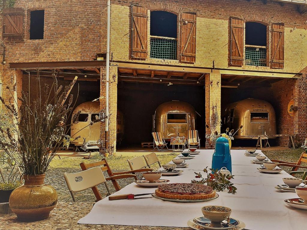 une grande table avec des assiettes et des bols en dessus dans l'établissement Airstream Hotel, à Kahla