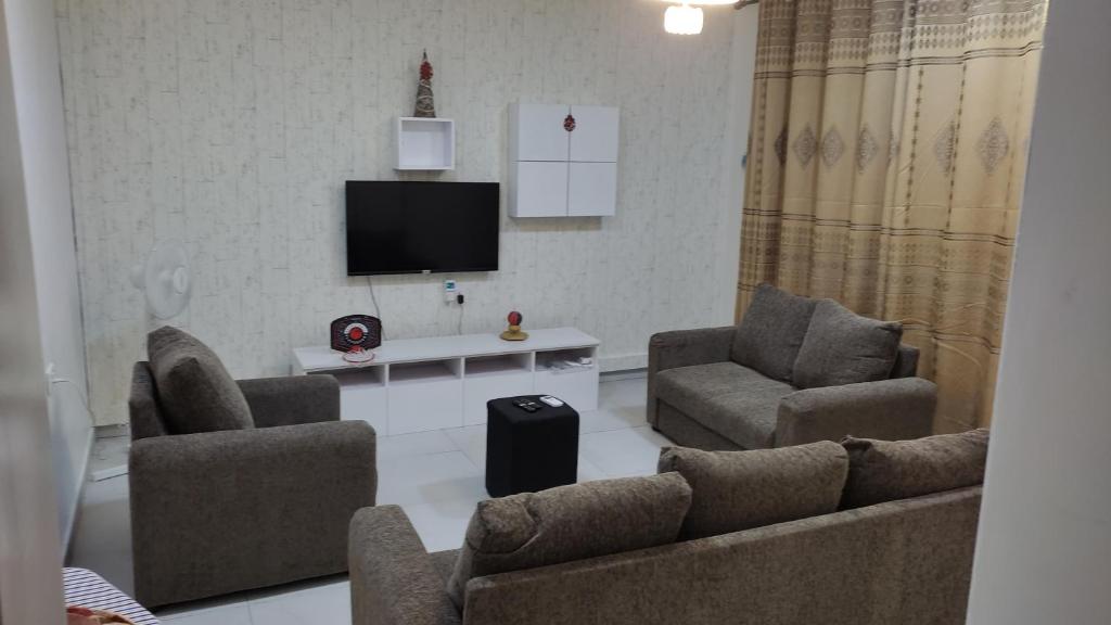 a living room with two chairs and a tv at La Casa Maite - Stunning Studio Apartment in Bortianor