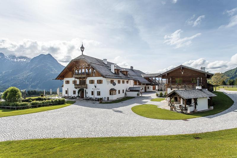 a large white house with mountains in the background at Winterstellgut in Annaberg im Lammertal