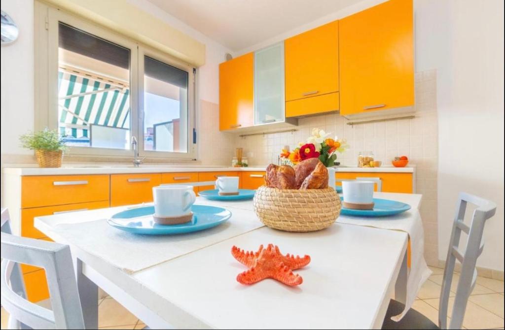 uma cozinha com armários laranja e uma mesa com estrelas do mar em Piazza del Sole Apartment em San Salvo