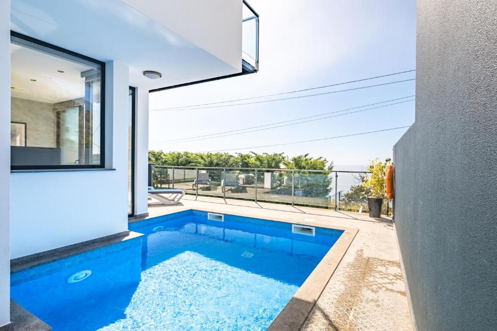 una piscina al centro di una casa di Hillside Villa ad Arco da Calheta