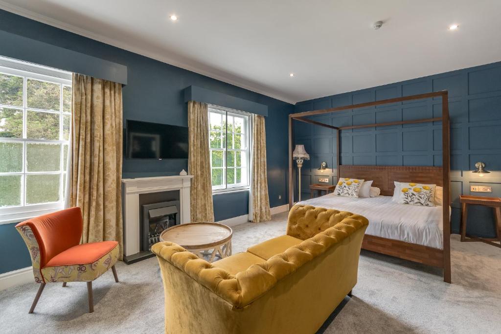 een slaapkamer met een groot bed en een bank bij The Northwick Arms Hotel in Evesham