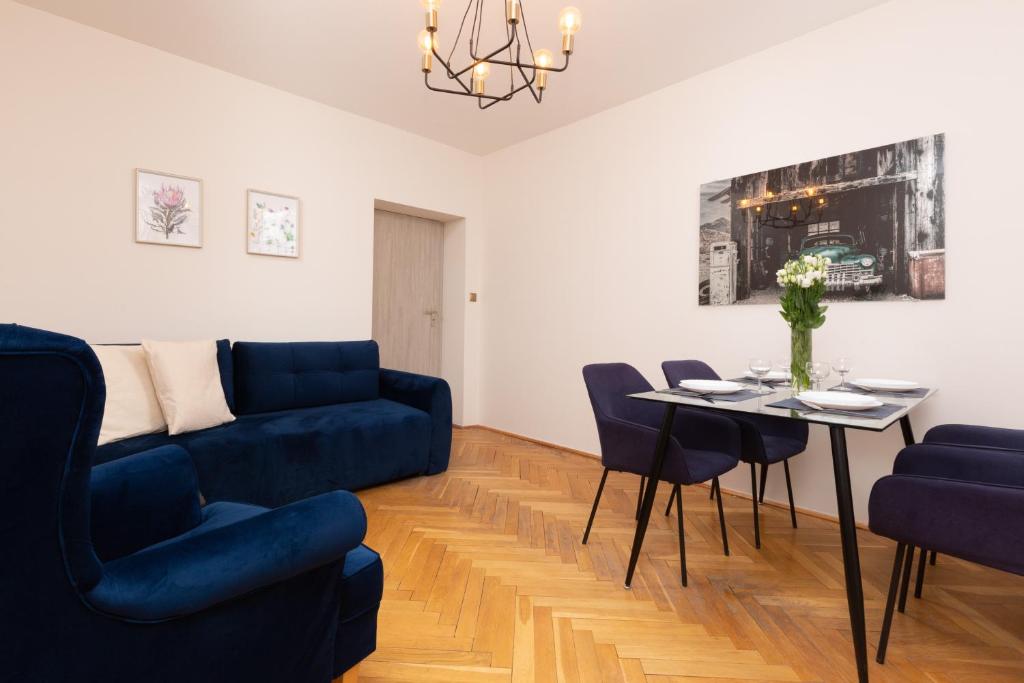 a living room with a blue couch and a table at City Center Apartment Elektoralna by Renters in Warsaw