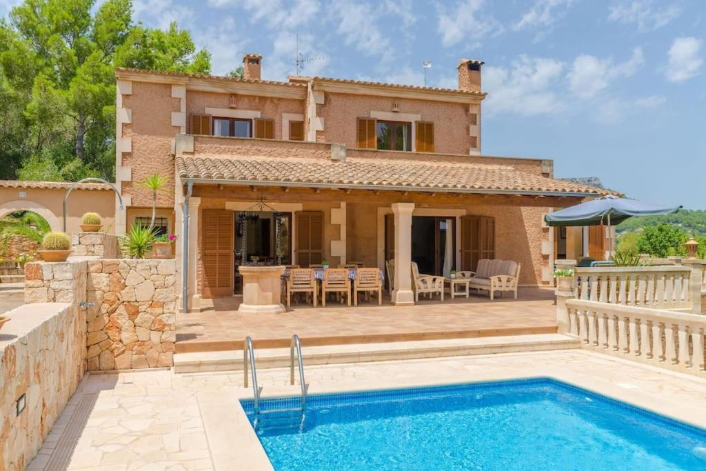 a villa with a swimming pool in front of a house at Es Turó de França in Calonge