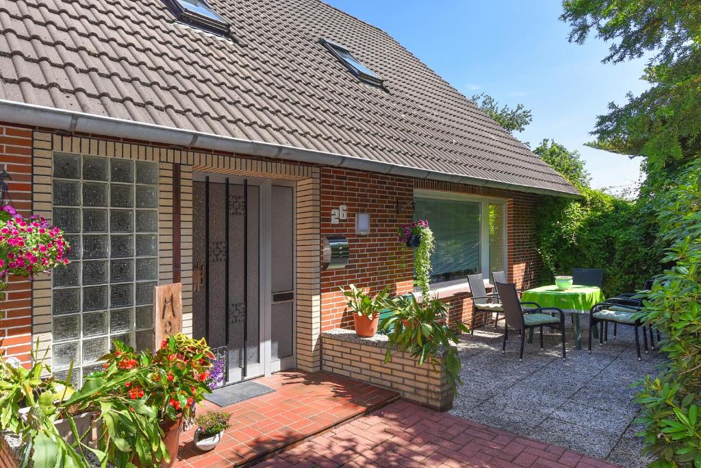 a brick house with a patio with a table and chairs at Ferienhaus Elfriede Coordes in Moorweg
