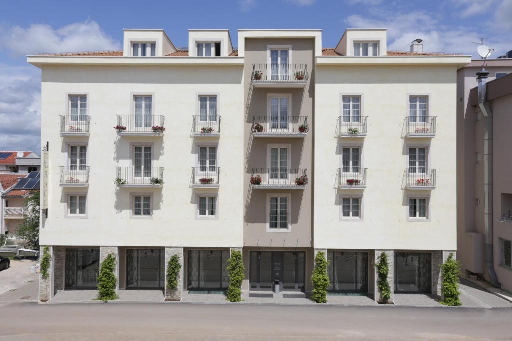 a large white building with windows at Hotel Villa Grace in Međugorje