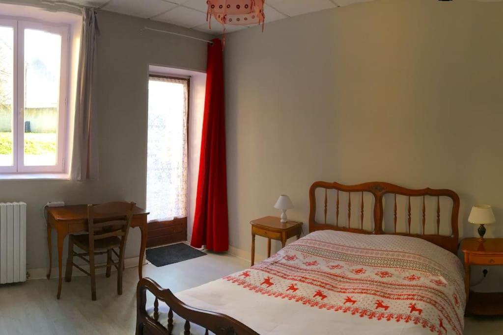 - une chambre avec un lit, une table et une fenêtre dans l'établissement Grand T3 avec cour intérieure, à Gray