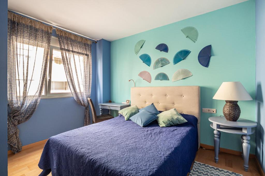 - une chambre dotée d'un mur bleu avec des parasols dans l'établissement FORUM BEACH 2 AND POOL APARTMENT BARCELONA, à Barcelone