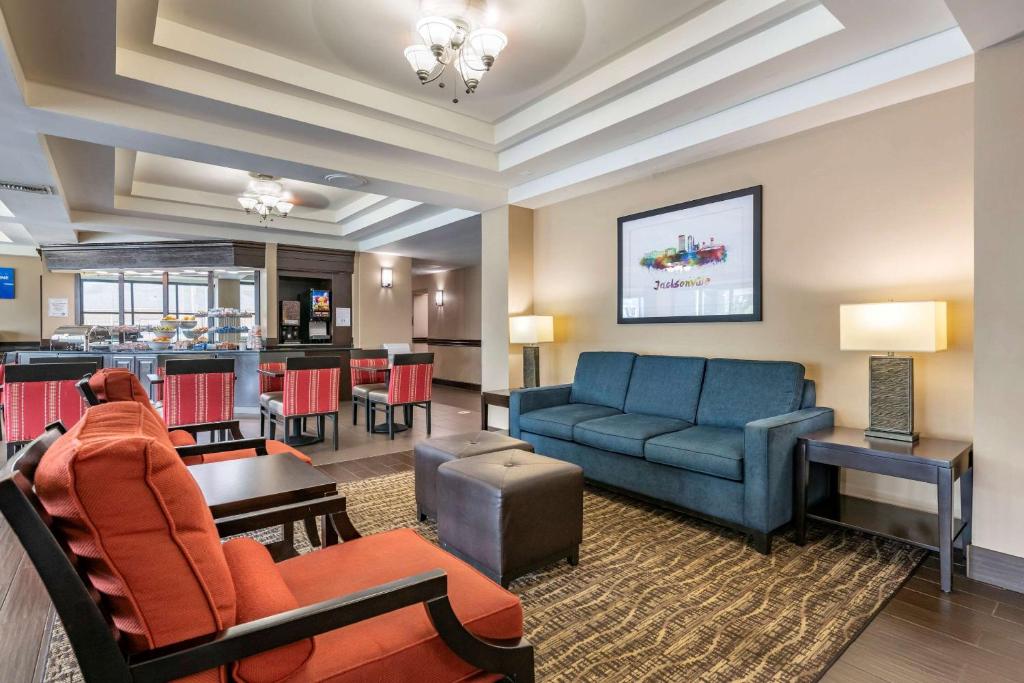 Comfort Suites Baymeadows Near Butler Blvd في جاكسونفيل: غرفة معيشة مع أريكة وطاولة