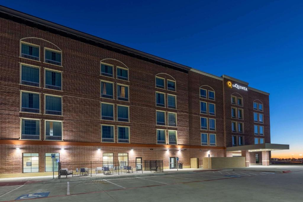 einen Blick nach außen auf ein Hotel in der Nacht in der Unterkunft La Quinta Inn & Suites by Wyndham Dallas - Frisco Stadium in Frisco