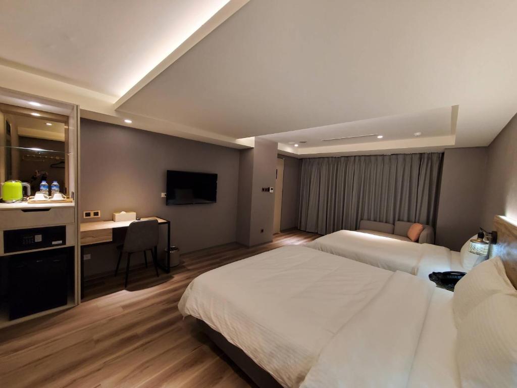 a hotel room with a bed and a desk at HINOEN Hotel in Taipei