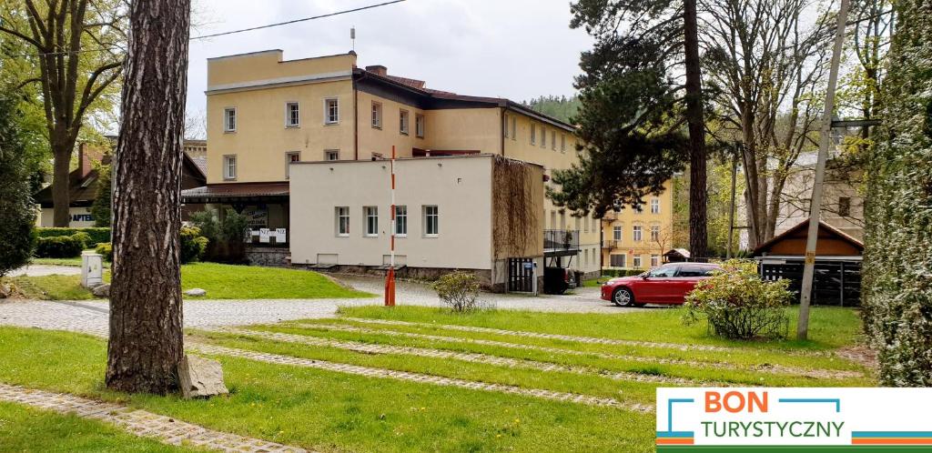 un edificio con un coche aparcado delante de él en Ośrodek Wypoczynkowy HEL, en Lądek-Zdrój