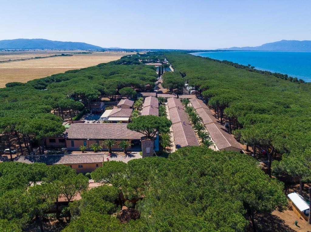 une vue aérienne sur une école arborée et l'océan dans l'établissement Golfo di Maremma Village, à Albinia